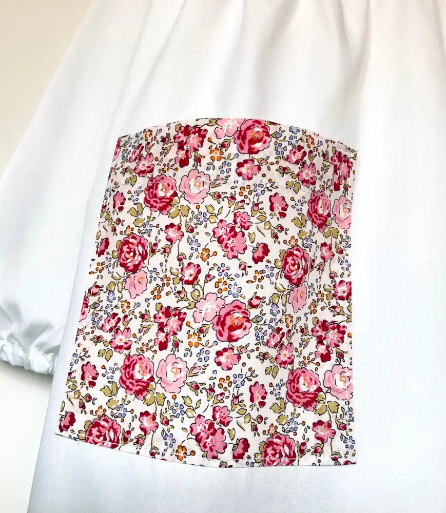 Il grembiulino con le rose e i lillà - Grembiule bianco per asilo con tasche a fiorellini rosa e colletto tondo