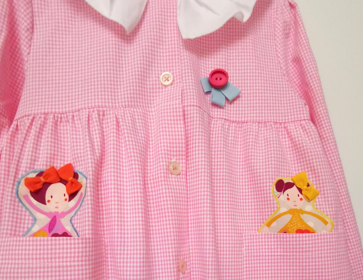 Le tablier avec les poupées - Tablier de maternelle à carreaux roses avec col pierrot