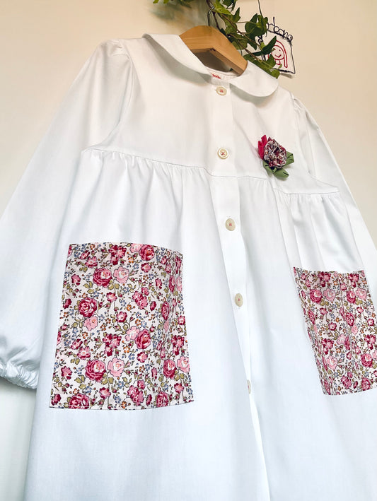 The apron with roses and lilacs - White apron for kindergarten with pockets with pink flowers and round collar
