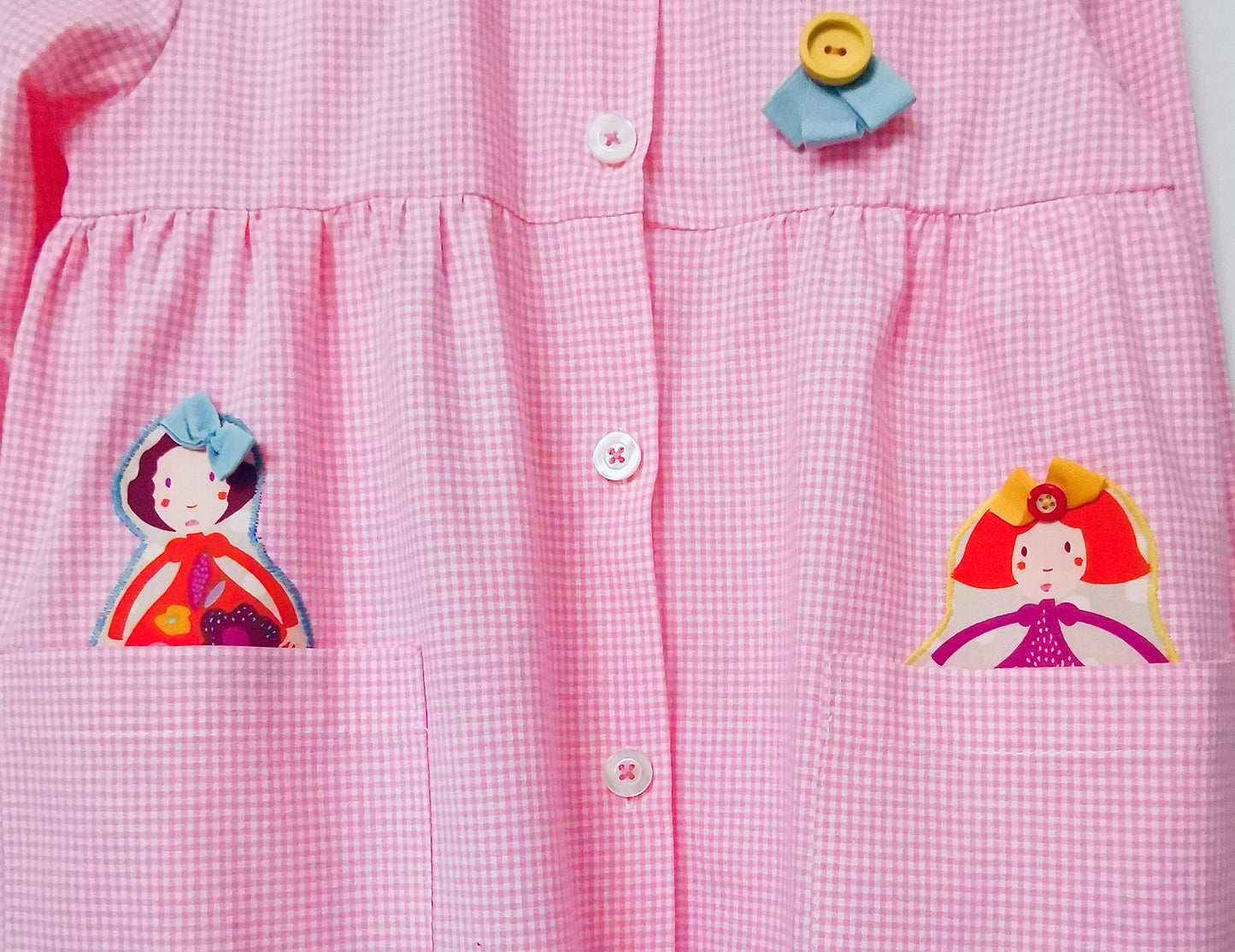 Le tablier avec les poupées - Tablier de maternelle à carreaux roses avec col pierrot