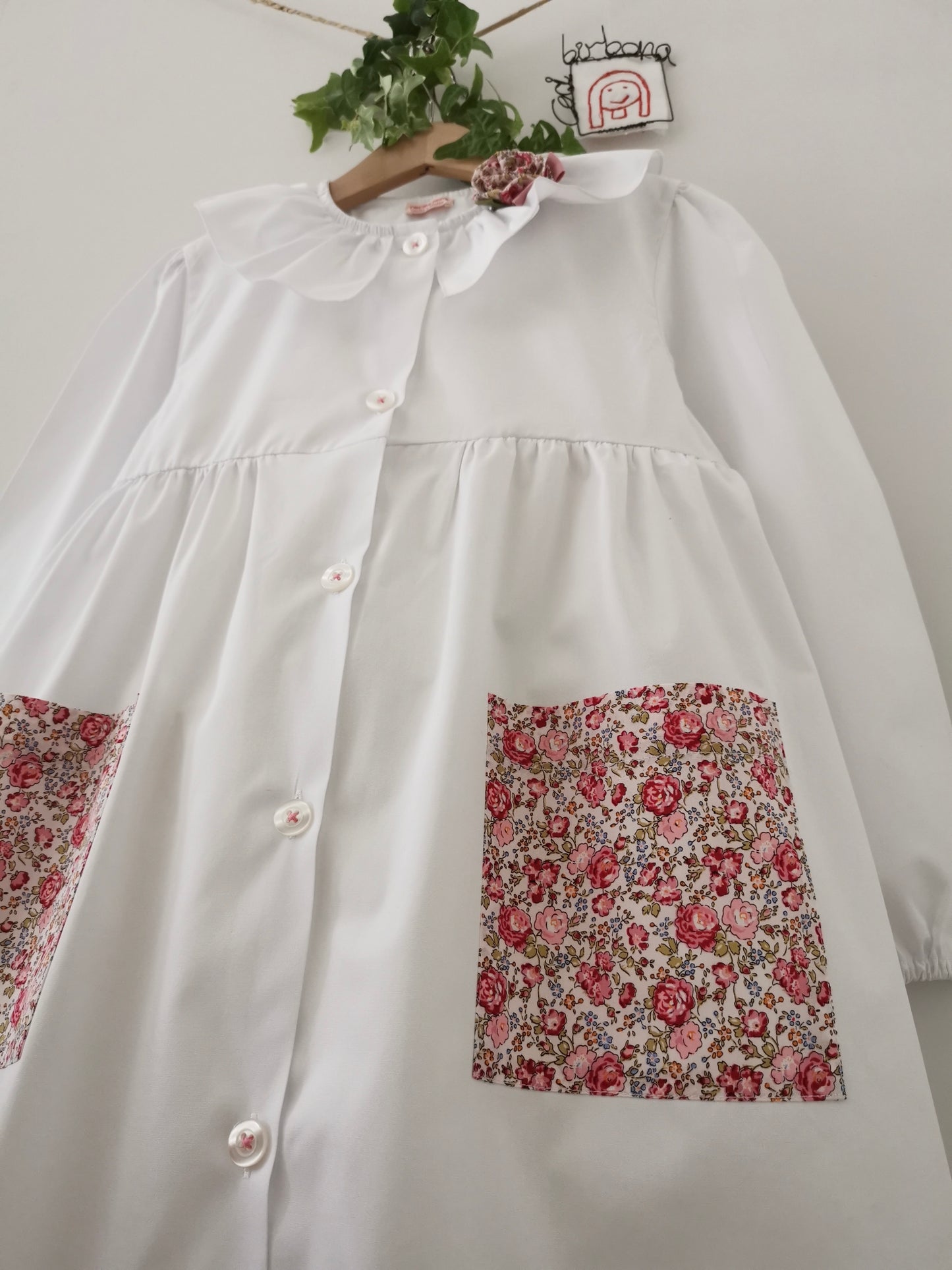The white apron with roses and forget-me-nots and pierrot collar for primary school